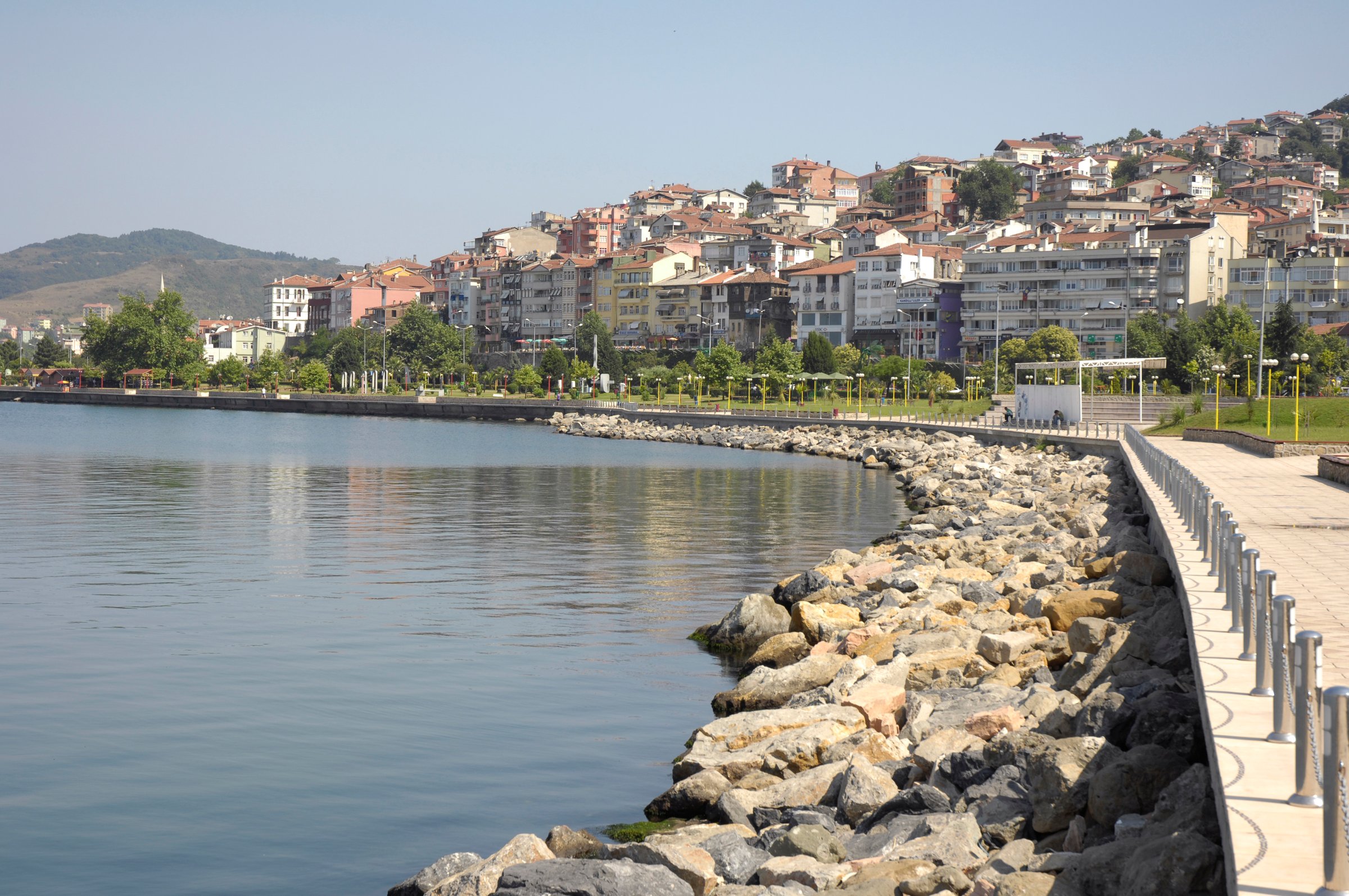 Taş dalgakıran boyunca uzanan sahil yürüyüş yolu ve yamaçtaki yerleşim